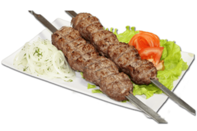 Готовый люля-кебаб с помидорами и листьями латука на тарелке