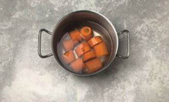 Морковь хорошо вымыть, очистить от кожуры, порезать на несколько частей, переложить в кастрюлю и залить водой.