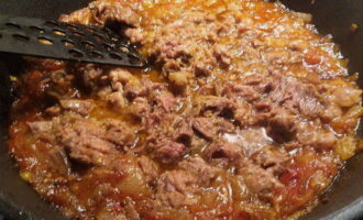 Добавьте в сковороду макароны с мясным соусом. Перемешайте и убавьте огонь до минимума. 