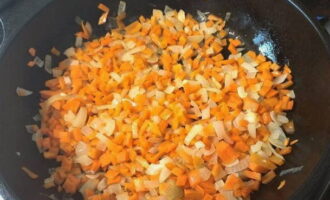 Готовим жаркое. Лук и морковь очистить, нарезать кубиками и обжарить на растительном масле около 2-4 минут до мягкости.