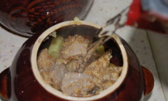 В кастрюли выложить картошку, потом мясо. Залить горячей водой.