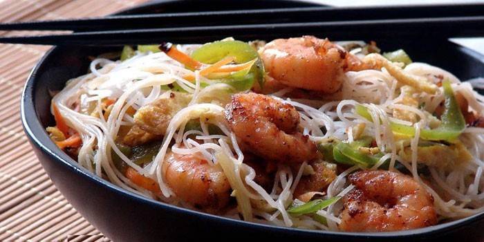 Морепродукты с рисовой лапшой на тарелке